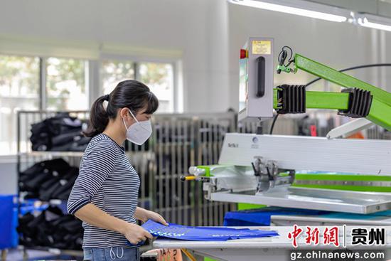 9月12日，工人在服饰生产车间进行服装加工。