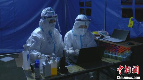 黔东南州援助贵阳方舱实验室检测队员对核酸检测样本进行信息录入。　曾浩洋 摄