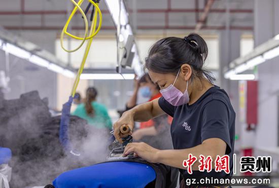 2022年9月12日，工人在贵州质品服饰有限公司生产车间进行服装加工。