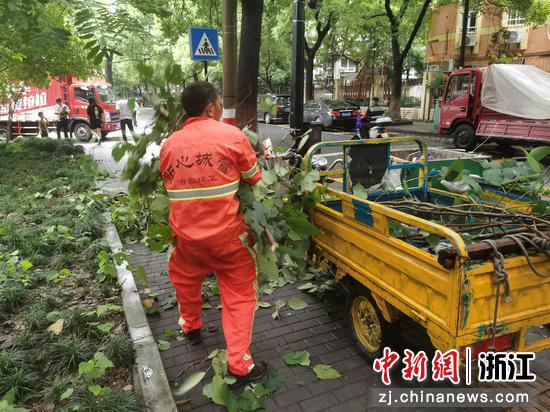 环卫工人对树枝进行清理。拱墅区委组织部供图