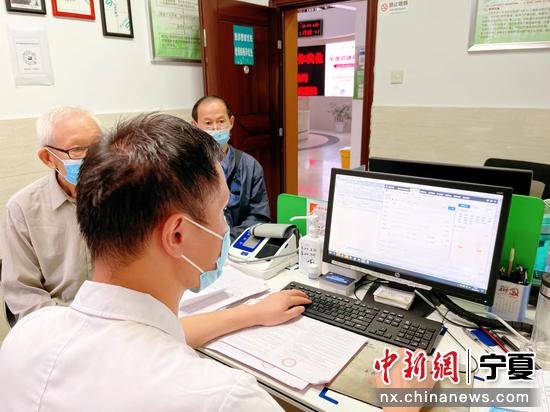宁夏固原市西吉县吉强镇袁河村卫生室医生使用智医助理为村民看诊。