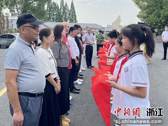 学生代表为杭州衢州商会党支部党员系红领巾。张斌 摄