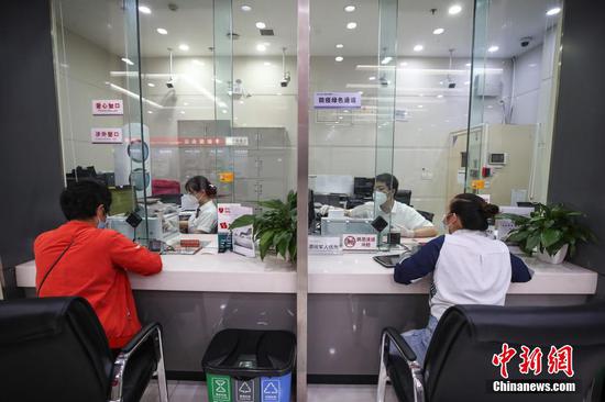 1/8
9月22日，中国工商银行一网点工作人员在给市民办理业务。日前，根据工作安排，贵阳经济技术开发区部分行业陆续复工复产。 瞿宏伦 摄