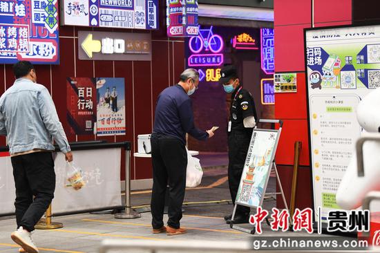9月24日，在贵阳市南明区青云路步行街青云市集防疫卡点，工作人员正在查验市民的“贵州健康码”和“大数据行程卡”。