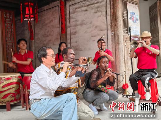 刘鸿武（左二）、约罗（左四）、留学生（左五）一起学习演奏中国民间传统乐器。王剑波 摄