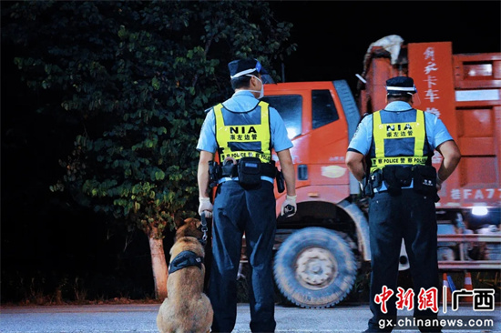 图为该总站移民管理警察携带警犬在重点路段执勤。