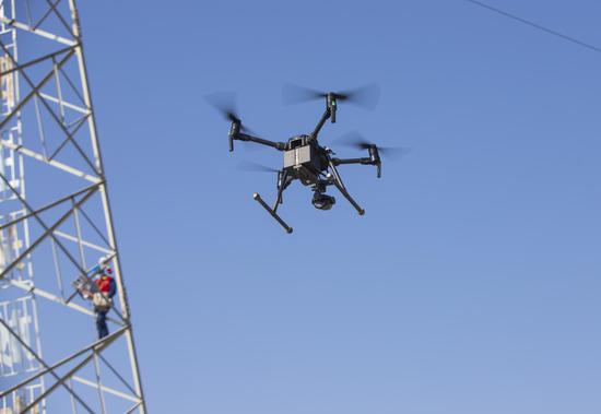 国网乌鲁木齐供电供电公司工作人员利用无人机巡视重要输电线路。王晋魁 摄