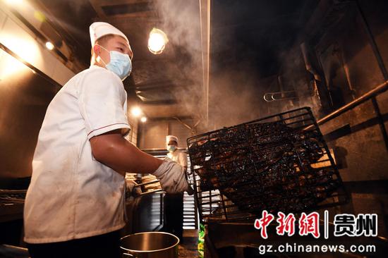 10月2日,贵阳市南明区一烤鱼店工作人员正在烤制烤鱼。