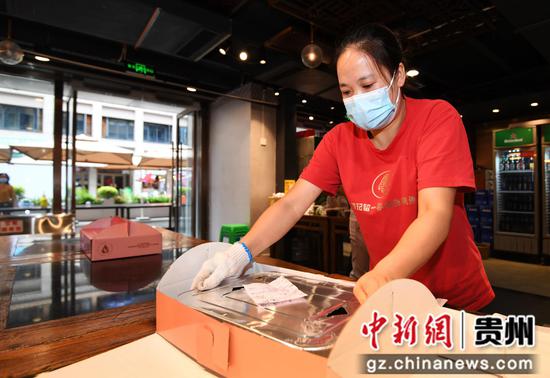 10月2日，贵阳市南明区一烤鱼店的服务员正在包装市民定制的烤鱼。