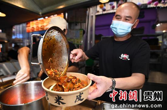 10月2日，贵阳市南明区“青云市集”一小吃店的工作人员正在加工制作烤米皮。