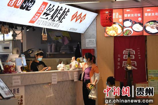 10月2日，市民在贵阳市南明区“青云市集”一小吃店内提取定制的食品。
