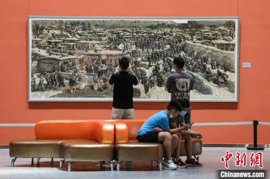 “历史的语言”第五届中国油画双年展展出的作品《村庄》吸引市民参观。　瞿宏伦 摄