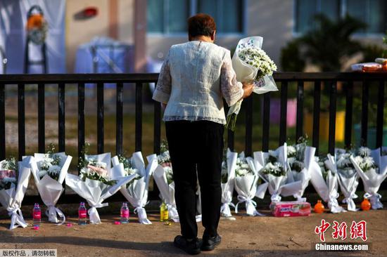 泰国民众在发生恶性伤害事件的磨兰普府幼儿园外献花悼念遇难者。