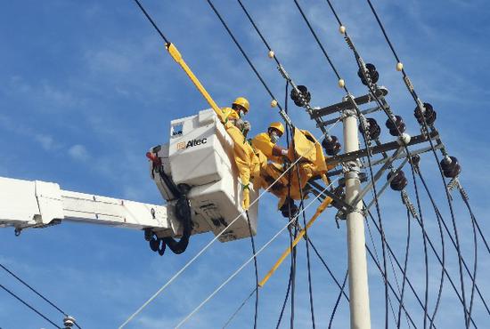 10月4日，国网哈密供电公司带电作业人员在110千伏轻工业园10千伏轻油一线开展带电消缺作业。阿丽亚·莫明 摄
