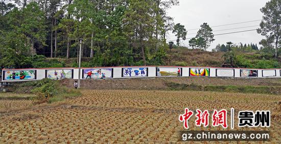 2022年10月13日，在贵州省黔西市铁石苗族彝族乡油沙坡村新时代文明实践站，教师志愿者正在彩绘墙体。 熊军万    摄