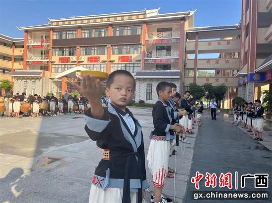 图为王尚小学的学生展示民俗技艺——掌上转陀螺。韦佳秀 摄