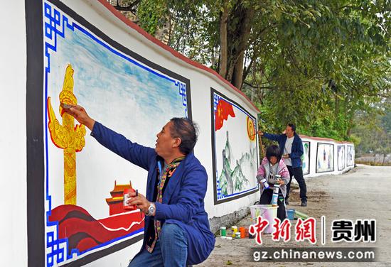 2022年10月13日，在贵州黔西铁石苗族彝族乡油沙坡村新时代文明实践站，教师志愿者正在彩绘墙体。熊军万摄