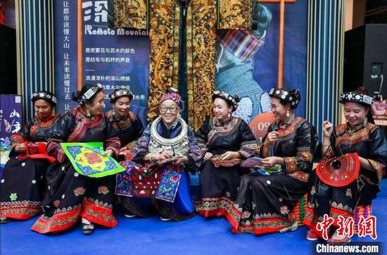 图为潘玉珍老人(中)与其他绣娘一起展示刺绣技艺。　受访者供图