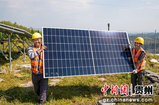2022年10月25日，贵州省黔西市定新一期农业光伏电站项目施工现场，建设者在搬运光伏组件。