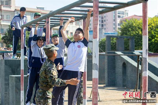 11月1日，学生们在官兵的保护下体验军事训练。