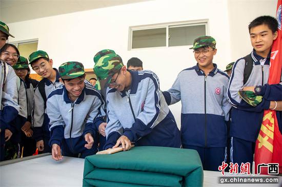 11月1日，学生们在武警官兵的指导下体验叠被子。
