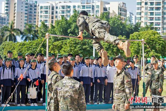 11月1日，一名武警官兵在为学生们表演器械体操。