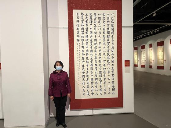 天津市政协委员、农民书法家刘智莉与她的书法作品。庞喻文 摄