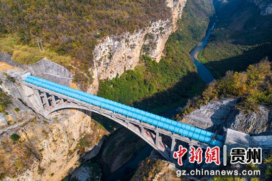2022年11月11日拍摄的贵州夹岩水利枢纽重点工程西溪河倒虹管跨河拱桥桥体和桥面输水管道（无人机照片）。