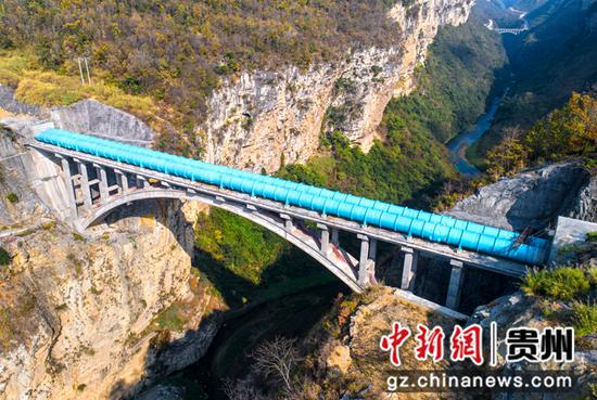 2022年11月11日拍摄的贵州夹岩水利枢纽重点工程西溪河倒虹管跨河拱桥桥体和桥面输水管道（无人机照片）。