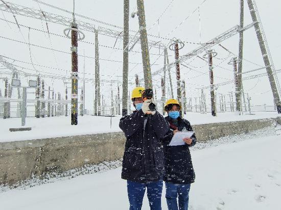 11月18日，國網哈密供電公司變電運維人員在220千伏山北變電站開展雪中特巡工作。陸萬杰 攝