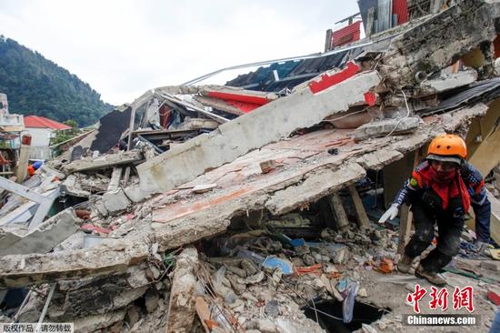 截至当地时间11月22日下午，印尼西爪哇省展玉县5.6级地震致死人数已升至268人，另有151人失踪、1083人受伤。震区展玉县政府启动了地震应急响应，宣布灾区进入为期一个月的紧急状态，期限自本月21日至12月20日。图为当地时间11月22日，一名救援人员行走在瓦砾间。