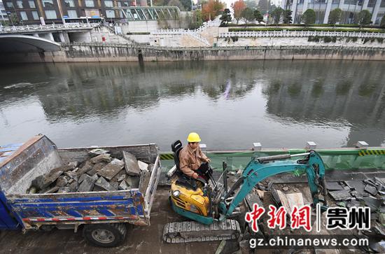 11月22日，施工工人正在贵阳市南明区青云法治廉政文化广场至筑城广场段拆除河道旁老旧破损跑步绿道。