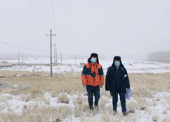 11月20日，国网和布克赛尔县供电公司员工在雪中巡视10千伏莫乡线。吴茜 摄