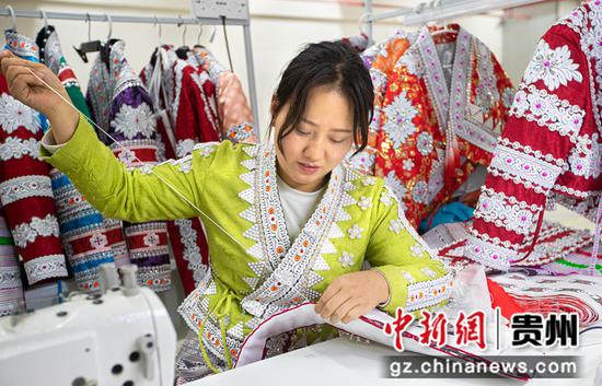 2022年11月23日，贵州省黔西市经济开发区（岔白园区）内一家苗族服饰加工车间，工人在加工苗族服饰。