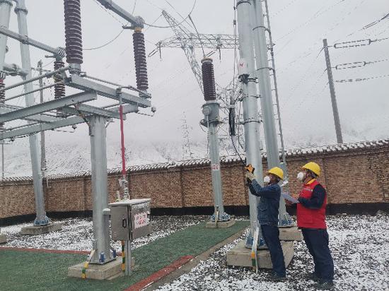 11月20日，国网喀什供电公司变电运维人员对110千伏慕士塔格变电站户外一次设备进行红外测温。梅佳佳 摄