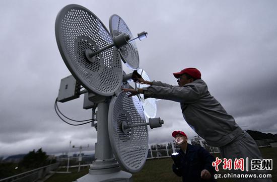 12月1日清晨，贵阳高空气象探测站工作人员擦拭雷达镜头浮冰， 为精准跟踪探测高空气象数据夯实基础。