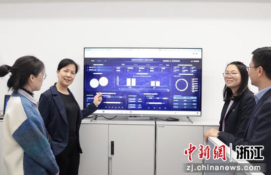胡海涛（左二）与部门员工交流财务共享金控运营分中心的建设情况。 浙江国贸 供图