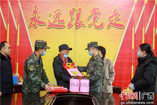 武警官兵正在为老党员赠送生活物资。贾广华 摄