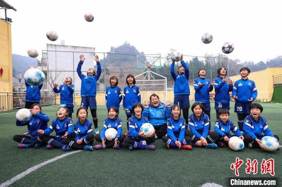 图为12月9日，“元宝女子足球队”教练徐召伟(中)和部分队员合影。　瞿宏伦 摄