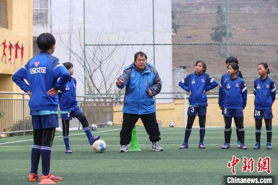 图为12月9日，“元宝女子足球队”教练徐召伟在给队员们讲解足球基本战术。　瞿宏伦 摄