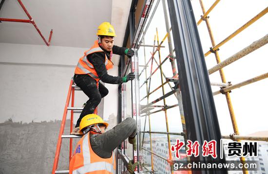 12月12日，在贵阳市南明区南明智能制造产业园三期项目建设现场，中铁八局集团第三工程有限公司的工人正在安装窗户玻璃。