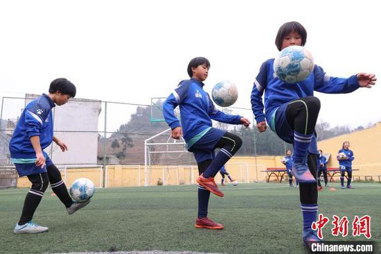 图为吴玉梅（中）与元宝女子足球队的队员一起练习颠球。　瞿宏伦　摄