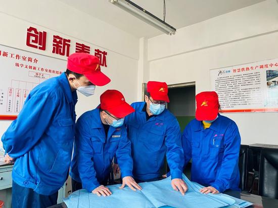 自治区“劳模”、广汇热力工程师钱学文（右二）指导青年员工。