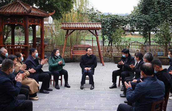 徐麟在枫香镇花茂村同村民们围坐在一起亲切交谈。