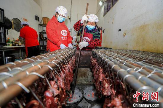 工人在贵州省江口县一家旅游食品加工作坊，烘烤牛肉制作牛干巴。　李鹤 摄