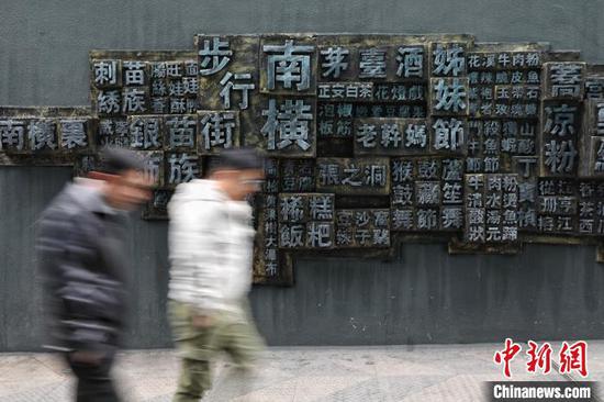 12月6日，市民经过贵阳市南横街浮雕墙。　瞿宏伦 摄