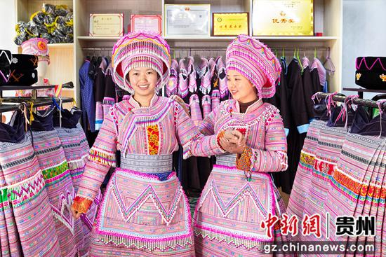 2022年12月14日，贵州省黔西市红林彝族苗族乡鱼塘村一家苗族服饰加工车间，村民展示刚加工好的苗族服饰。