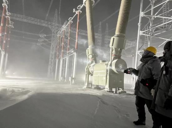 11月26日，国网新疆超高压分公司员工在750千伏喀纳斯变电站进行极寒天气设备特巡工作。（董辉 摄）