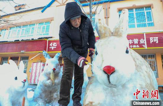61岁的阿不都克因·阿不都哈德尔每年在同一个地点制作生肖雪雕，传扬生肖文化已21年。　杨俊钦　摄