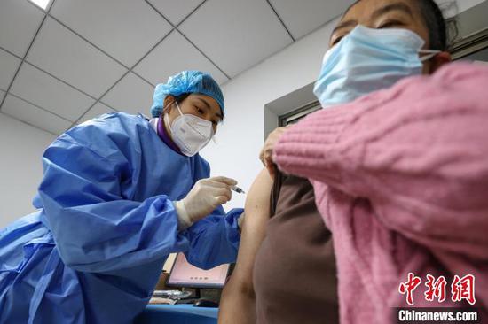 12月23日，遵义市新蒲新区康华医院疫苗接种点内，市民在进行新冠病毒疫苗第二剂次加强免疫接种。　瞿宏伦 摄